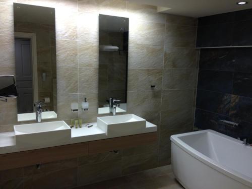a bathroom with two sinks and a tub at Swell Boutique Hotel in Rethymno Town