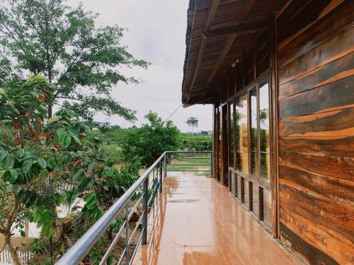 uma varanda de uma casa com vista para a floresta em FOREST BREATH ECO-LODGE em Tân Phú