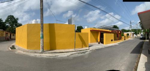 a yellow building on the side of a street at Hotel La Piramide Izamal in Izamal