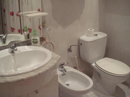 Baño blanco con lavabo y aseo en Hostal Villamañez, en Madrid