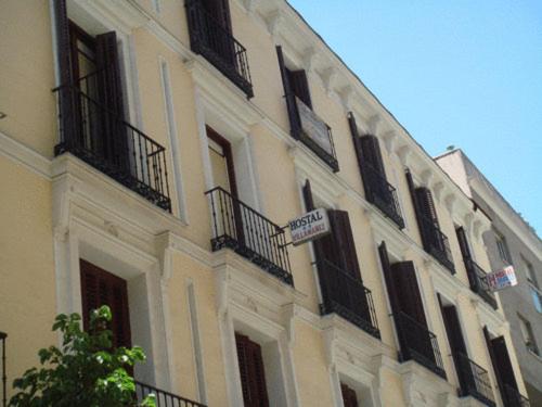 un gran edificio blanco con ventanas y balcones negros en Hostal Villamañez, en Madrid