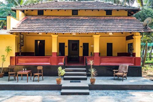 a house with a red and yellow at SaffronStays Suvarna Sangam, Udupi in Udupi