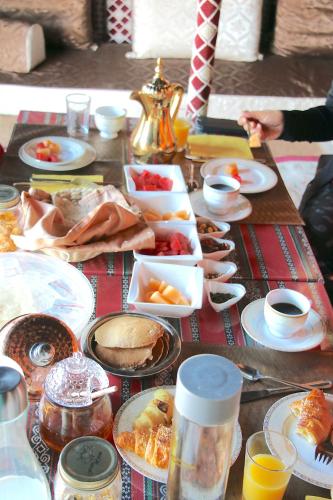 a table topped with food and plates of food at Starwatching Private Camp in Ḩawīyah