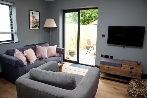 a living room with two couches and a flat screen tv at Little Elm - luxury home from home, free parking, 30-40 mins walk from Bath city centre in Bath