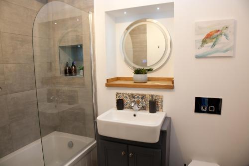 a bathroom with a sink and a shower and a mirror at Little Elm - luxury home from home, free parking, 30-40 mins walk from Bath city centre in Bath