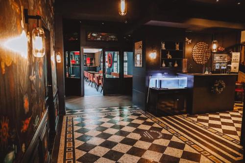 a room with a checkered floor in a restaurant at Hôtel De Wimereux in Wimereux