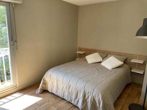 - une chambre avec un lit avec deux oreillers et une fenêtre dans l'établissement T3 Arcachon centre proche plage, à Arcachon