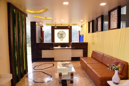 a living room with a couch and a table at Khushi Riverside Resort & Spa in Mahabaleshwar
