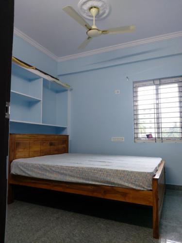 een slaapkamer met een bed en een plafondventilator bij FEEL LIKE HOME near Cricket stadium in Visakhapatnam