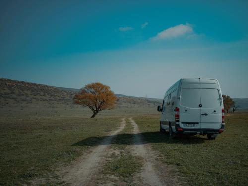 庫塔伊西的住宿－Geo Campers - Full time living camper rental in Kutaisi, Tbilisi, Batumi, Georgia，停在土路上的白色货车