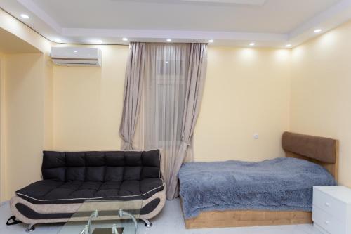 a bedroom with a couch and a bed in it at BEST CHOICE in Old Tbilisi City Center in Tbilisi City