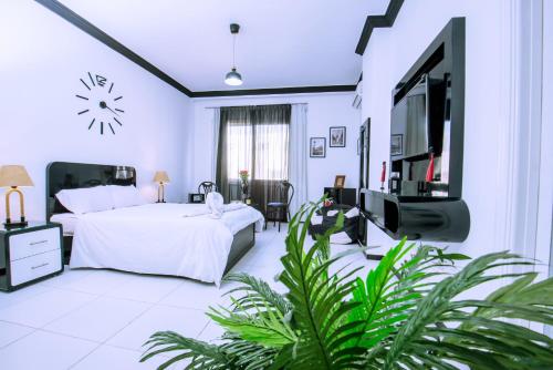 um quarto com uma cama e uma televisão de ecrã plano em Rare 2BD Marina Hotspot With Pool, Fast Free WIFI & Balcony - 2 Kitchens & 2 Bathrooms - Western Standards - Sheraton Plaza 414-415 em Hurghada