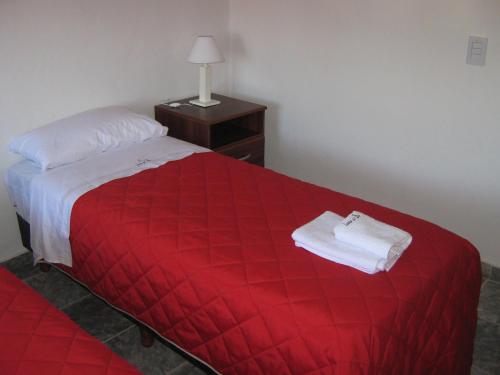 Habitación de hotel con cama roja y manta roja en Cabañas Luna del Sur en Merlo