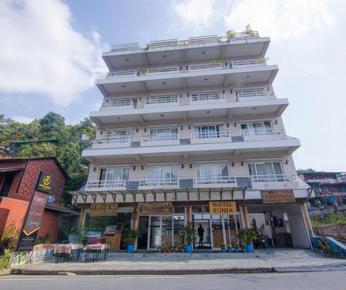 a large white building on the side of a street at Hotel Kunja in Pokhara