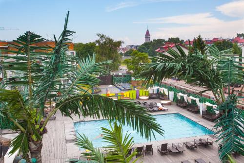 a view of a resort with a pool and palm trees at Apartament Carlos in Władysławowo