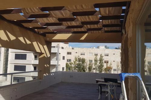 an outdoor patio with a table and a building at Penthouse overlooking Jordan valley in Amman