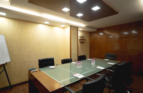 a conference room with a large table and chairs at The Fern Residency, Subhash Bridge, Ahmedabad in Ahmedabad
