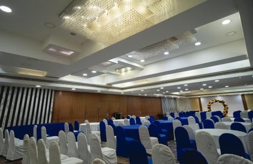 a banquet hall with blue chairs and white tables at The Fern Residency, Subhash Bridge, Ahmedabad in Ahmedabad