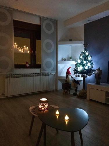 a living room with a christmas tree and a table at Apartman Coelum Delnice in Delnice