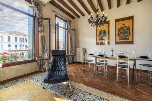 una sala da pranzo con tavolo, sedie e finestre di Rialto Grand Canal a Venezia