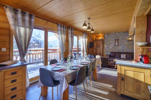 een eetkamer met een lange tafel met stoelen bij Les Balcons du Golf in L'Alpe-d'Huez