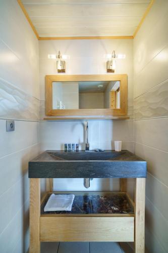 a bathroom with a sink and a mirror at Alpe d'Huez Houses - Les Balcons du Golf in L'Alpe-d'Huez