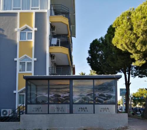 a building with a window with a painting of the ocean at REGA OTEL in Antalya