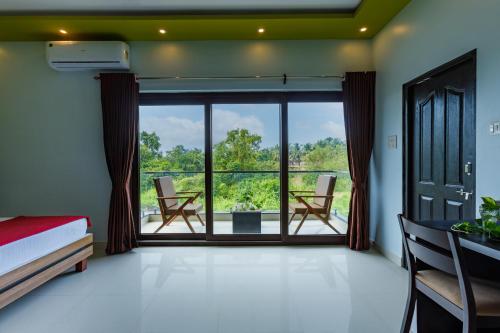 a bedroom with a bed and a large window at Om Shanti Residence in Canacona