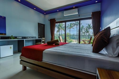 a bedroom with a large bed and a large window at Om Shanti Residence in Canacona