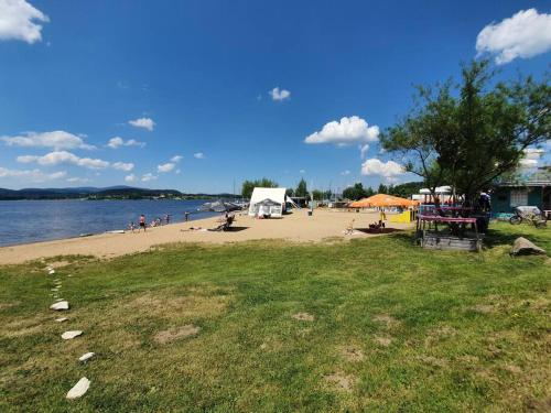 a beach with people on the sand and water at Relax Vila Lipno- apartmán v podkroví u pláže Windy Point in Černá v Pošumaví