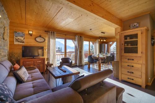 a living room with a couch and a table at Les Balcons du Golf in L'Alpe-d'Huez