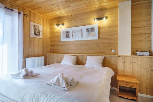 two beds in a room with wooden walls at Alpe d'Huez Houses - Les Balcons du Golf in L'Alpe-d'Huez