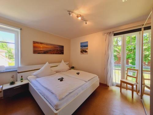 um quarto com uma grande cama branca e janelas em Strandläufer Villa Rosita mit Garten em Rerik