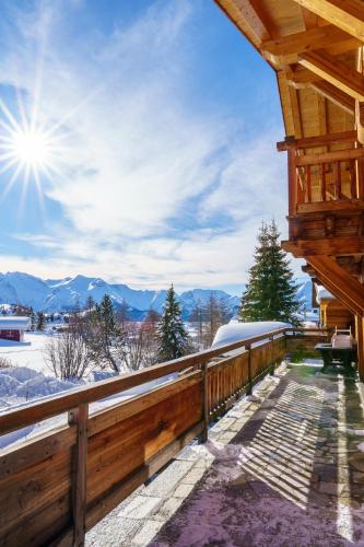 a wooden balcony with a view of the mountains at Alpe d'Huez Houses - Les Balcons du Golf in L'Alpe-d'Huez
