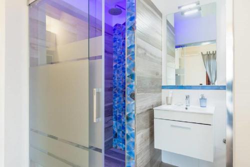 La salle de bains est pourvue d'une douche et d'un lavabo blanc. dans l'établissement Emozioni D'artista, à Salerne