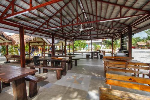 een groep tafels en banken in een paviljoen bij Lavigo Resort in Pantai Cenang