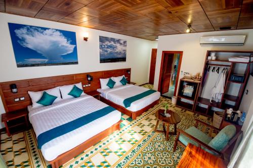 A bed or beds in a room at Sunbird Garden Resort
