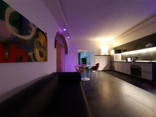 a living room with purple lighting and a kitchen at Vistaperdue in Peccioli