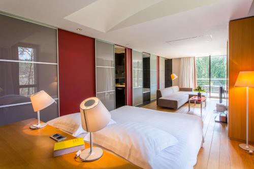 a bedroom with a white bed and a living room at Restaurant Hôtel L'Arnsbourg in Baerenthal