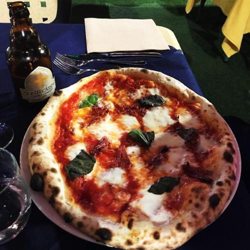 a pizza sitting on a plate on a table at Hotel Ristorante Al Boschetto in Cassino