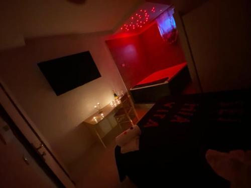 a person standing in a room with a bed and red lights at Hotel Napoleon-Cuore in Qualiano