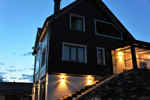 ein schwarzes Haus mit Lichtern an der Seite in der Unterkunft UnderДіл in Krivopolʼye