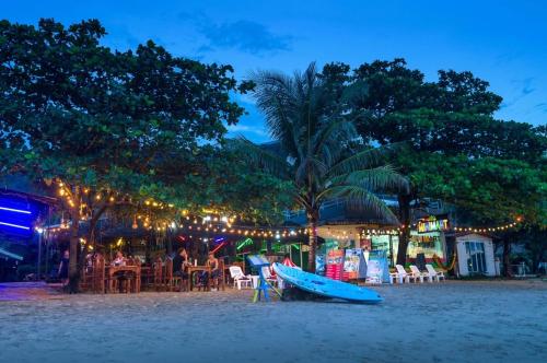 uma prancha de surf sentada na praia à noite em Klongdao Sunset Villa em Ko Lanta