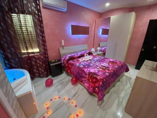 a bedroom with a purple bed with lights on the floor at Hotel Napoleon-Cuore in Qualiano