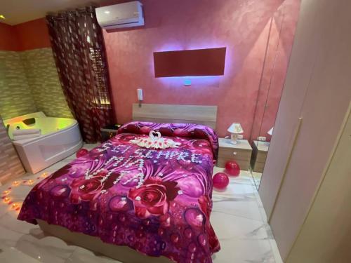 a bedroom with a bed with a purple comforter at Hotel Napoleon-Cuore in Qualiano