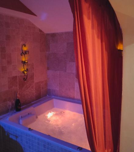 a bathroom with a tub with a red shower curtain at Une Parenthese pour Deux in Plan-dʼOrgon