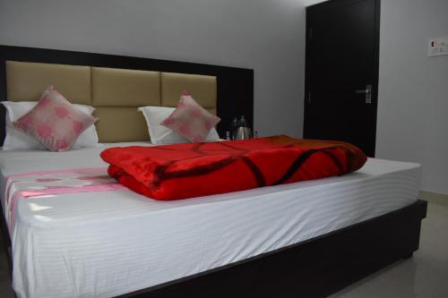 a red blanket laying on top of a bed at Bodhi Stay in Bodh Gaya