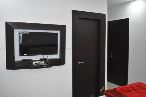 a flat screen tv on a wall next to a door at Bodhi Stay in Bodh Gaya