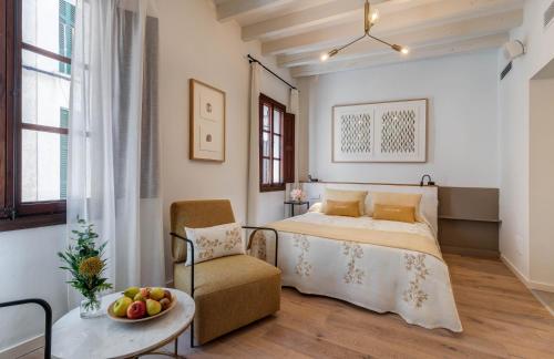a bedroom with a bed and a chair and a table at Ca’s Cuscanti in Sóller