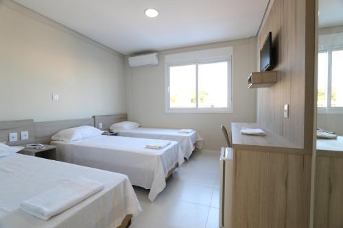 a hospital room with two beds and a window at Hotel Ville House Premium in Canoas